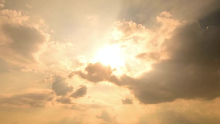 Golden hour sky filled with clouds and sunbeams creating a serene atmosphere