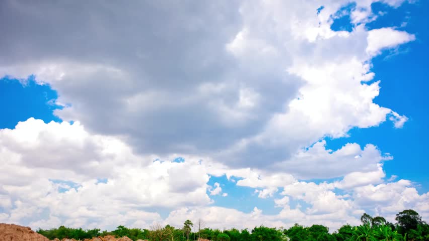 Bright blue sky filled with fluffy white clouds over a lush green landscape view