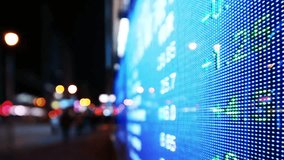 Stock market data displayed on a large outdoor screen at night in an urban setting - Powered by Shutterstock - Get 15% off with code: PIKWIZARD15