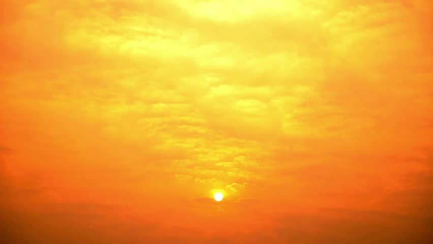 Golden sun shining brightly through a hazy orange sky at sunrise or sunset time