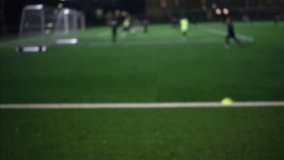 Night view of a football training session on an artificial turf field under bright floodlights with small goals and cones set up for youth practice - Powered by Shutterstock - Get 15% off with code: PIKWIZARD15