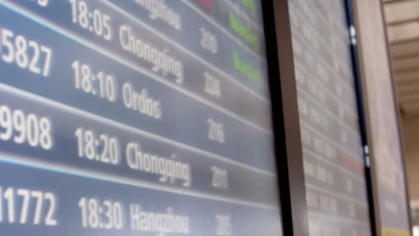 Airport departure board displaying flight information with times and destinations