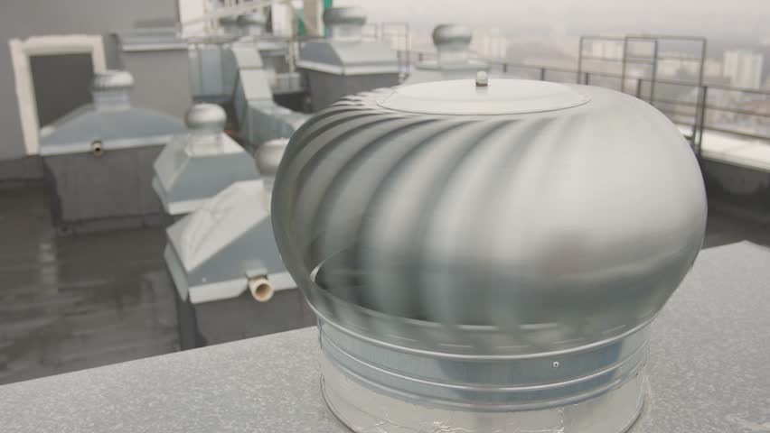 Steel turbine vents on rooftop, Metal ventilation units on city roof top, Closeup of industrial metallic roof vents featuring geometric design and muted gray tones