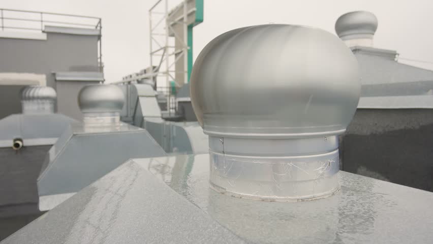 Steel turbine vents on rooftop, Metal ventilation units on city roof top, Closeup of industrial metallic roof vents featuring geometric design and muted gray tones