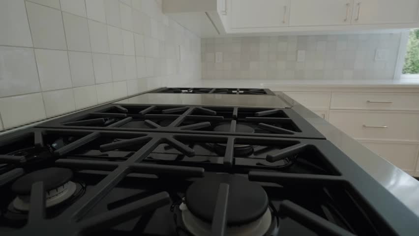 Close-up of a gas stove and worktop in a modern kitchen, highlighting sleek design, cooking setup, and contemporary home interior details.