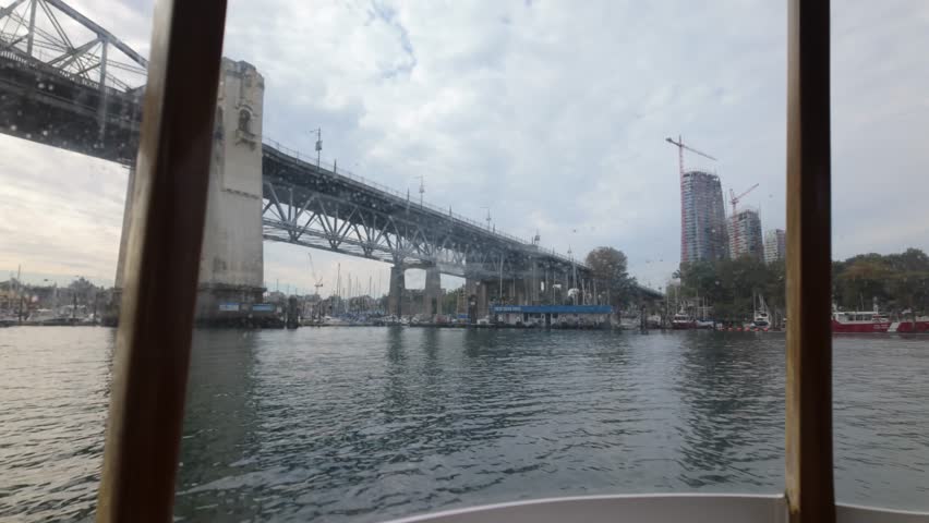 Boat POV shot from a False Creek Ferry traveling under the Burrard Bridge in Vancouver, British Columbia, Canada. 4K