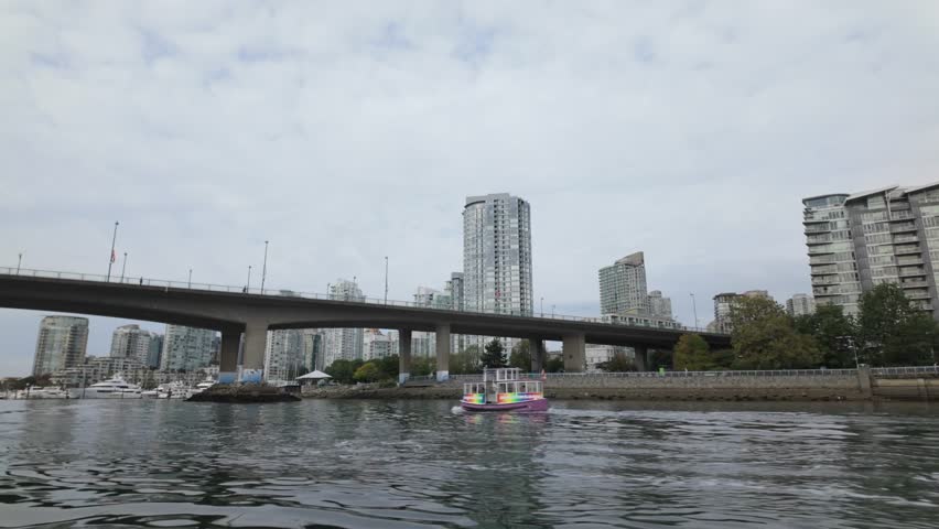 Gimbal shot from a moving boat of an Aquabus ferry heading towards Cambie Bridge on False Creek in Vancouver, British Columbia, Canada. 4K