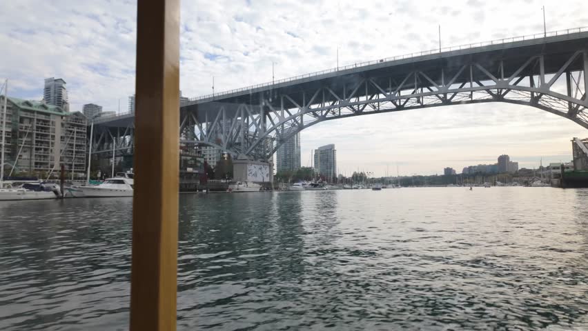 Boat POV shot traveling underneath the Granville Bridge on the False Creek Ferry in Vancouver, British Columbia, Canada. 4K