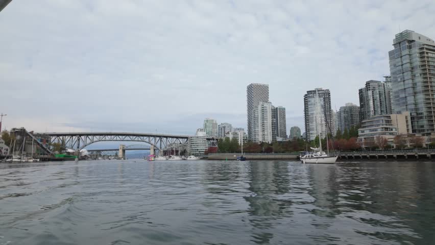 Gimbal shot from a moving boat of David Lam Park along False Creek during autumn in Vancouver, British Columbia, Canada. 4K