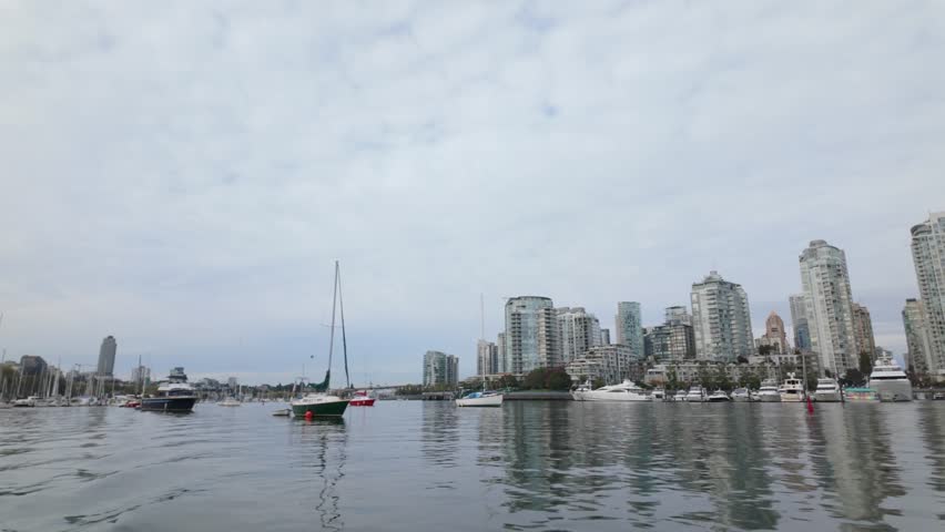 Gimbal shot of boats on False Creek as seen from a moving ferry in Vancouver, British Columbia, Canada. 4K