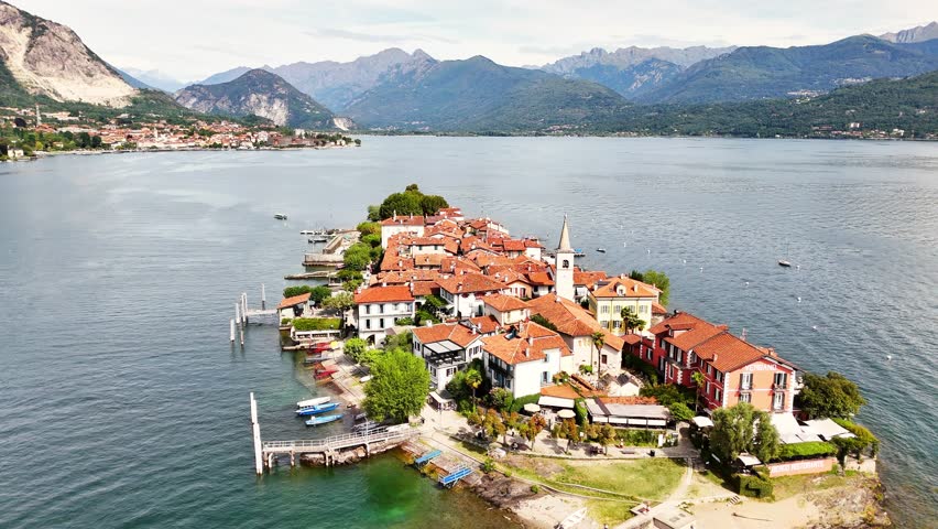 Aerial view of Sresa on Isola Bella in Italy featuring terracotta rooftops, waterfront homes, clear lake waters and surrounding mountains creating a scenic lakeside village setting with coastal charm