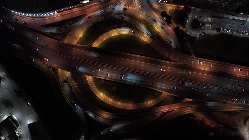Intersection of multiple roads on a double roundabout drone rotation top down view at night