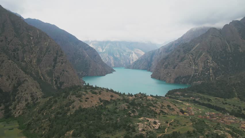 Above Shey Phoksundo Lake, a drone captures vivid turquoise water bordered by sheer Dolpa cliffs and silent Himalayan wilderness. This rare aerial view shows Nepal’s untouched natural wonder.