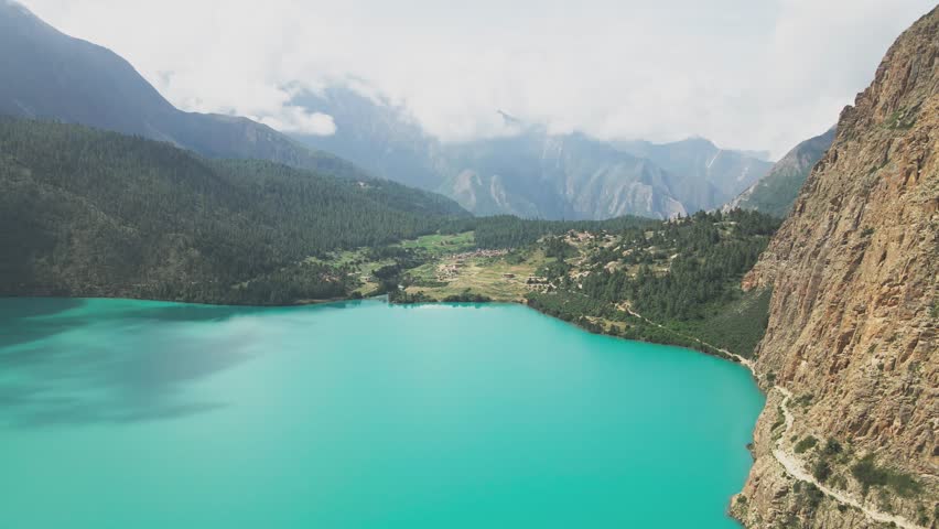 A drone floats over Shey Phoksundo Lake, revealing turquoise depth against Dolpa’s vertical cliffs and vast Himalayan silence. This aerial scene highlights Nepal’s untouched wilderness at its purest.