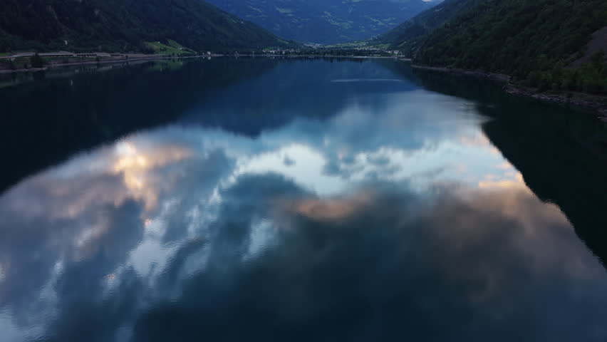 Clouds Reflected On A Mountain Lake At Sunset In Switzerland. Aerial Wide Shot