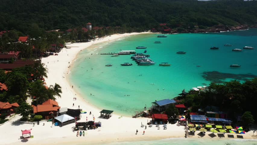 Aerial view of Long Beach with clear turquoise waters and vacationing tourists on Redang Island. Malaysia