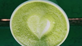 Close up of a frothy matcha latte with heart-shaped latte art - Powered by Shutterstock - Get 15% off with code: PIKWIZARD15