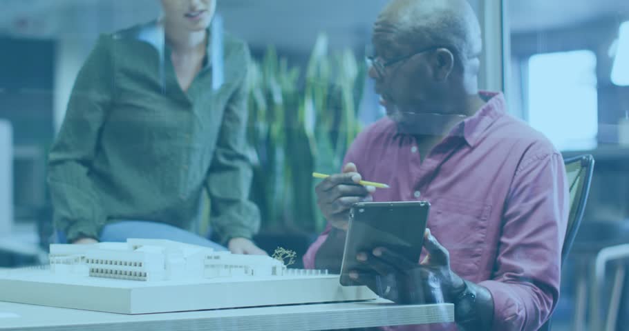 Senior man holding tablet sliding yellow pencil to female architect, pointing and refining model. Collaboration, architecture, design, scale, office, teamwork, discussion