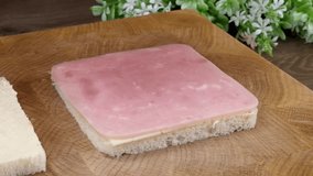 Hand preparing a classic ham and cheese sandwich on white bread slices - Powered by Shutterstock - Get 15% off with code: PIKWIZARD15