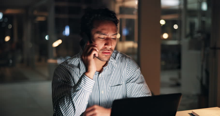 Man, laptop and phone call at night, startup or confused with contact, talk or advice at media company. Person, editor or writer with smartphone, tired or communication on overtime at creative agency