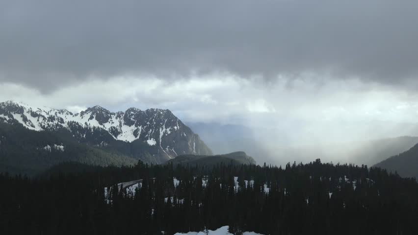 Aerial drone shot flying over the snowy mountains of Mount Rainier during winter, showcasing a vast white landscape.
