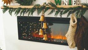 Warm fireplace with green pine garland and hanging bells, cozy winter home decor details - Powered by Shutterstock - Get 15% off with code: PIKWIZARD15
