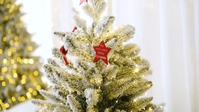 Decorated frosted evergreen tree with lights and red star ornaments indoor setting - Powered by Shutterstock - Get 15% off with code: PIKWIZARD15