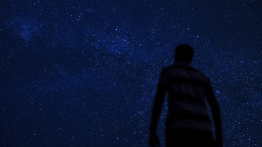 Silhouette of a man under the twinkling Milky Way stars.