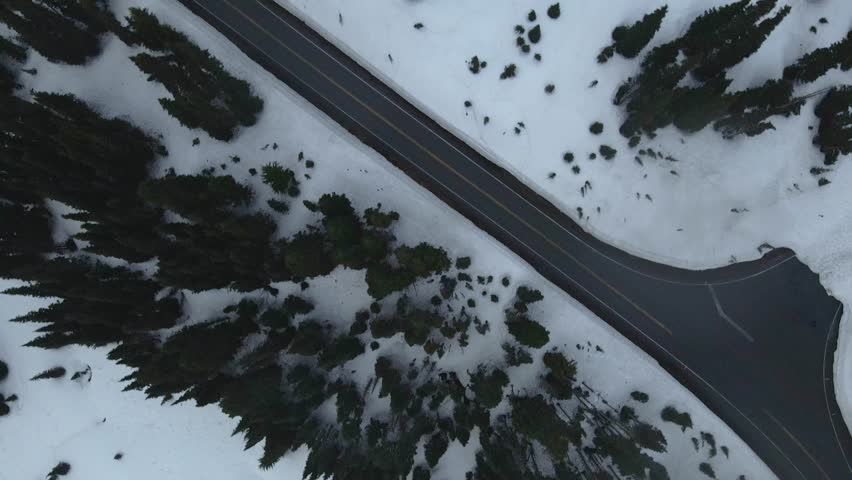 Aerial drone shot flying over the snowy mountains of Mount Rainier during winter, showcasing a vast white landscape.