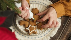 Making Christmas gingerbread. Female Hands Decorating Christmas Gingerbread Cookies with Green Icing - Powered by Shutterstock - Get 15% off with code: PIKWIZARD15