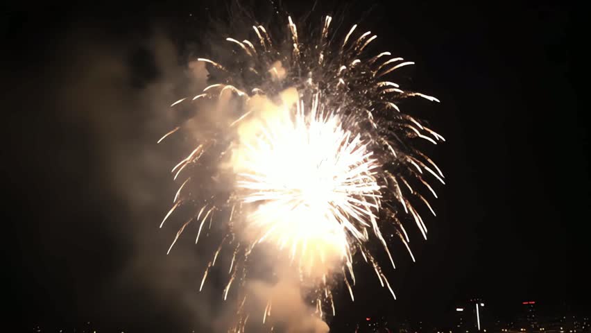 Spectacular Nighttime Firework Display Over a City Waterfront with Stunning Reflections on the Water Surface