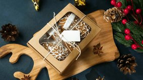 Christmas cookies gift box with snowflakes and pine cones on wooden surface - Powered by Shutterstock - Get 15% off with code: PIKWIZARD15