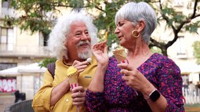 Cheerful elderly couple with grey hair enjoying a summer day in the city, laughing and sharing a sweet moment while eating delicious ice cream cones in a park, embodying active retirement - Powered by Shutterstock - Get 15% off with code: PIKWIZARD15
