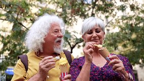 Elderly man and woman enjoying ice cream cones and laughing together while on vacation in a city park. Loving mature partners sharing a happy moment during their travels on a sunny summer day - Powered by Shutterstock - Get 15% off with code: PIKWIZARD15