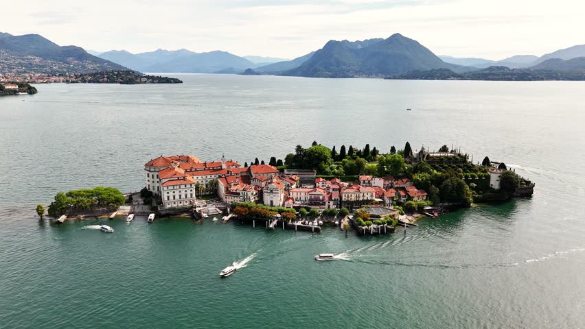 Drone establishing shot of Isola Bella, Lake Maggiore, Italy, Highlights Baroque Palazzo Borromeo, tiered gardens, and fishing village against the Alps backdrop, Stresa, VB, Piedmont region.