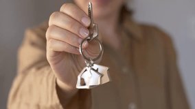 Woman holds out a keychain with house keys, symbolizing a new home, purchase, or rental agreement. Closeup shot focuses on the hand and keys, capturing a clean, bright moment of real estate transition - Powered by Shutterstock - Get 15% off with code: PIKWIZARD15