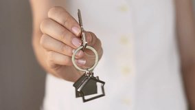Close-up of real estate agent holding house keys in one hand. Focus on the keyring between the fingers, highlighting the concept of an affordable home purchase, with bright, inviting background. - Powered by Shutterstock - Get 15% off with code: PIKWIZARD15