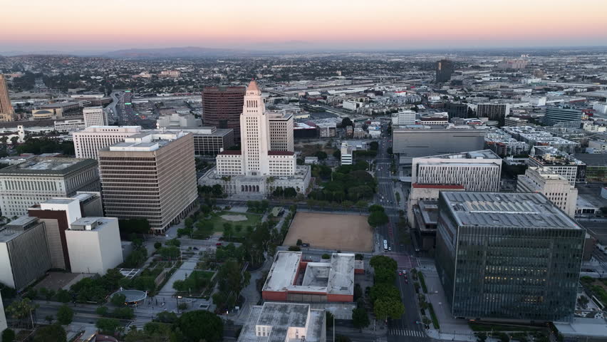 Aerial pan shot of the Los Angeles City Hall and downtown LA,, colorful dusk sky