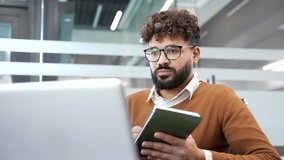 Businessman watching video call conference or training notes in notebook looking at laptop screen sitting at workplace in business office. Manager communicates online at a remote meeting. Close up - Powered by Shutterstock - Get 15% off with code: PIKWIZARD15