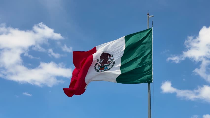 Mexico’s national flag fluttering on a clear, sunny day downtown