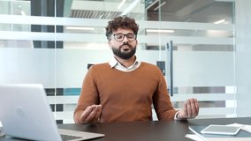 Businessman meditating with closed eyes during break while sitting at workplace in modern business office. Calm worker practices yoga, feels peace of mind. Male professional relaxes to relieve stress - Powered by Shutterstock - Get 15% off with code: PIKWIZARD15