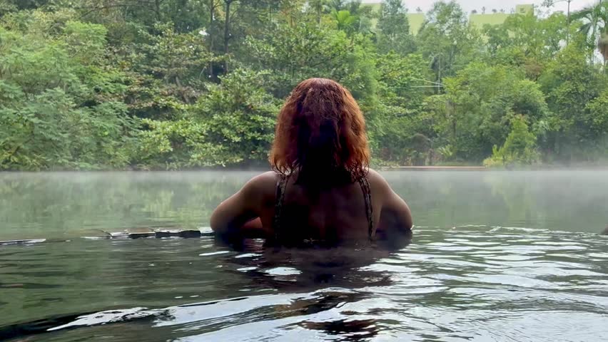 Woman back view at Natural Hot Springs pool in the jungle Perak province Malaysia