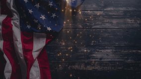 Overhead shot of the American flag draped on a rustic dark wooden surface, illuminated by shimmering golden particles. Perfect for patriotic holidays, celebrations, and historical themes. - Powered by Shutterstock - Get 15% off with code: PIKWIZARD15