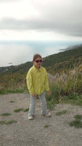 Happy Energetic Child Dances Funny On Scenic Mountain Viewpoint Vertical video.