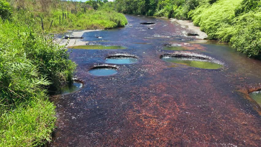 Aerial view of a blonde woman swimming in the natural jacuzzis of las gachas river in colombia