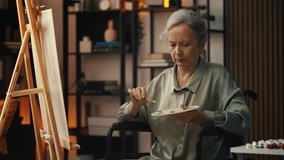 Senior woman in wheelchair painting on canvas in art class, creative hobby - Powered by Shutterstock - Get 15% off with code: PIKWIZARD15