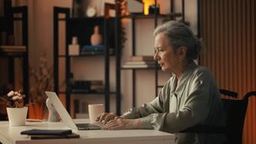 Senior woman wheelchair user typing on laptop at home, remote freelance job - Powered by Shutterstock - Get 15% off with code: PIKWIZARD15