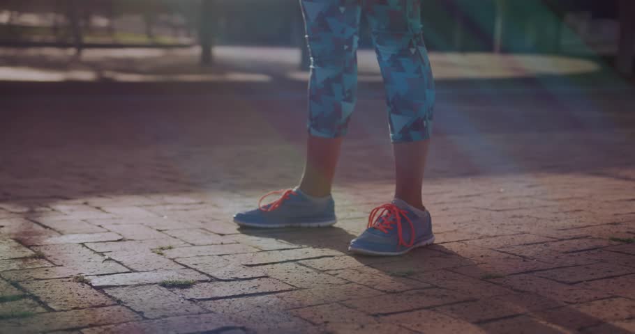 Woman doing fitness squats shifting weight on brick plaza, animated depth line tracking knees. Backlit, goldenhour, outdoor, athletic, movement, balance, focus