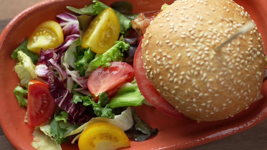 Delicious fresh hamburger with a side salad served on a plate