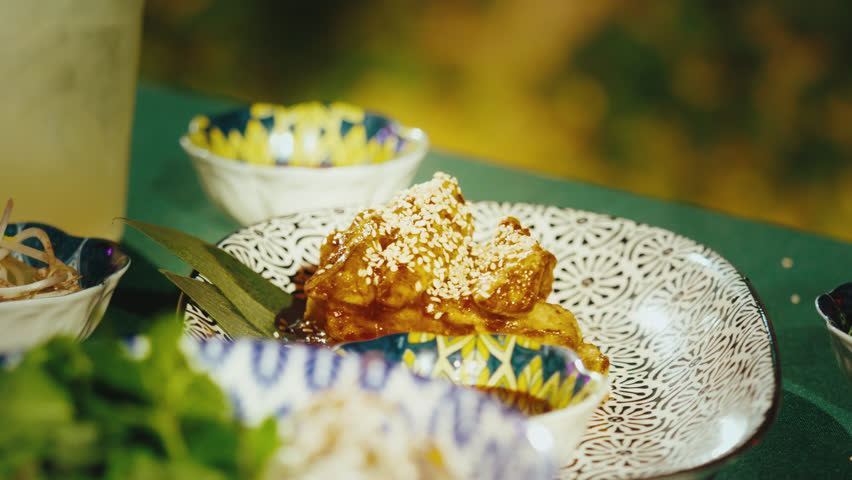 Chef Garnishing Crispy Eggplant in Sweet and Sour Sauce with Bean Sprouts